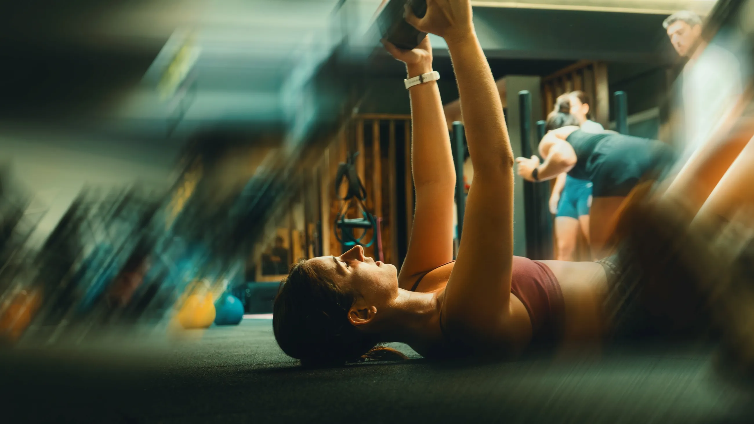 Mujer tumbada entrenando con una kettlebell en la sala de Garay